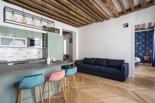 cocina y sala de estar con sofá azul en Typical Parisian Flat#3Bedrooms#Opera#Louvre, en París