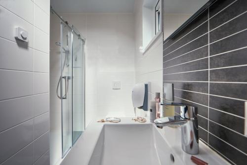 a white bathroom with a sink and a shower at Feriendorf Seeblick Toni in Kramsach