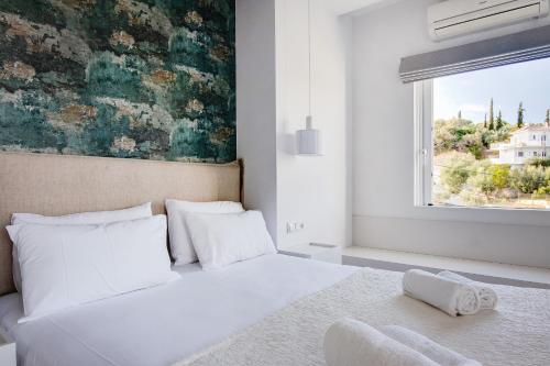 Peroulia Beach Houses في كوروني: غرفة نوم بسرير ابيض ونافذة