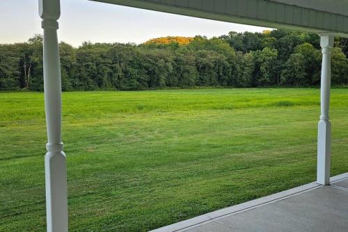 a view of a large field from a porch at GameRoom, HotTub, Piano, 5mi to OldManCave - Hocking Hills Copper House in Laurelville