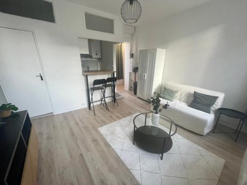 un salon avec un canapé blanc et une table dans l'établissement Studio Modern times a Rouen -280, à Rouen