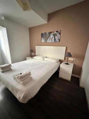 une chambre avec un grand lit blanc avec des serviettes dessus dans l'établissement Zerka Centro, à Valence
