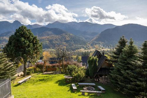 a garden with a picnic table and mountains in the background at Panorama Premium in Kościelisko