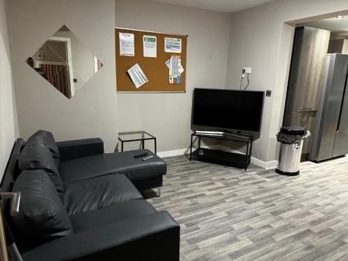 ein Wohnzimmer mit einem Sofa und einem Flachbild-TV in der Unterkunft SUPER 5 Bedroom House Sleeps 11! in Hull