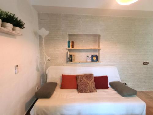 a bedroom with a white bed with two pillows at Casa Jaruf CENTRO HISTÓRICO Parking Gratuito Patio petfriendly in Arcos de la Frontera