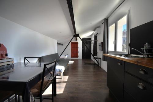 une cuisine et une salle à manger avec une table et des chaises dans l'établissement Studio industriel à 50 m de la plage et du port, à Mèze