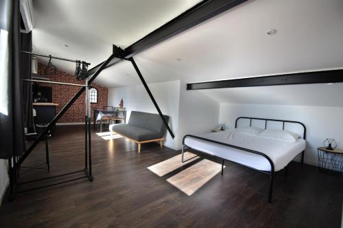 1 dormitorio con 1 cama y 1 silla en una habitación en Studio industriel à 50 m de la plage et du port, en Mèze