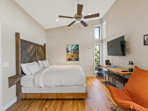 a bedroom with a bed with a ceiling fan and a desk at Pilot Cove in Pisgah Forest