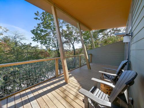 a porch with two chairs and a table on it at Pilot Cove in Pisgah Forest