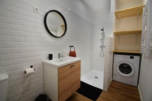 een badkamer met een wastafel en een wasmachine bij Appartement cosy à 50 m de la plage et du port in Mèze