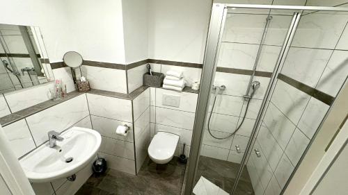 uma casa de banho com um chuveiro, um WC e um lavatório. em Brandstatthof - Hotel und Restaurant em Steingaden