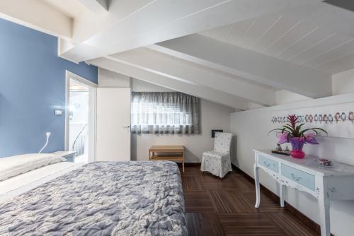 a bedroom with a white bed and a desk and a window at La Dimora nel Parco in Modena