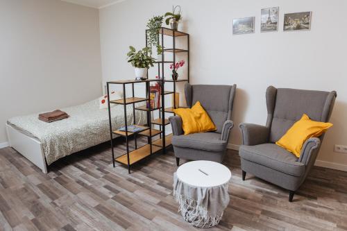 a living room with two chairs and a bed and a table at Apartment Katrina in Brocēni