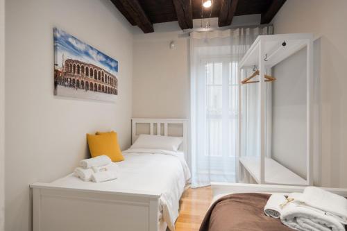 a white bedroom with two beds and a window at Flats4Rent Federica in Verona