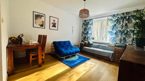 ein Wohnzimmer mit einem blauen Sofa und einem Tisch in der Unterkunft M&M Apartment Warsaw in Warschau
