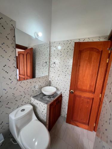 uma casa de banho com um WC, um lavatório e um espelho. em Refugio Khalma de la Montaña em Villa de Leyva