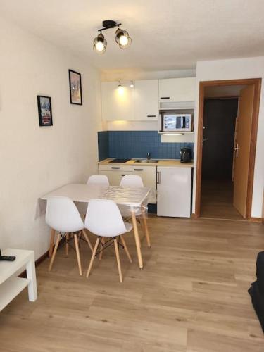 une cuisine et une salle à manger avec une table et des chaises dans l'établissement Appartement 4pers rénové de 24M2 pied des pistes, aux Orres