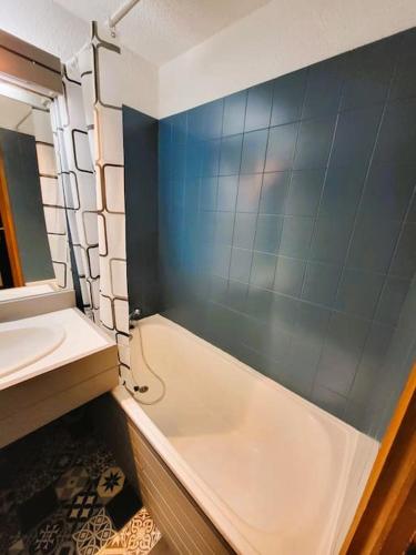 une salle de bain avec une baignoire et un lavabo dans l'établissement Appartement 4pers rénové de 24M2 pied des pistes, aux Orres