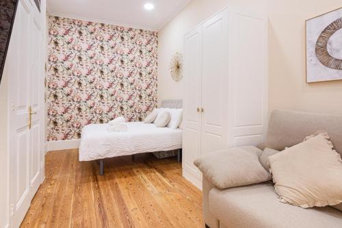 uma sala de estar com um sofá e um papel de parede floral em Céntrico Apartamento Vigo- Oporto Luxury em Vigo