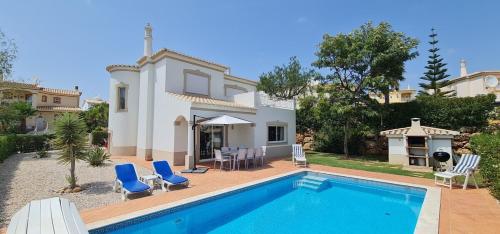 a villa with a swimming pool in front of a house at Four Bedroom Villa with private pool Oasis Parque AT09 in Portimão
