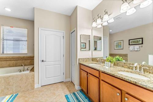 a bathroom with two sinks and a tub at Modern 8-Bed Champions Gate Disney Magic Awaits in Davenport