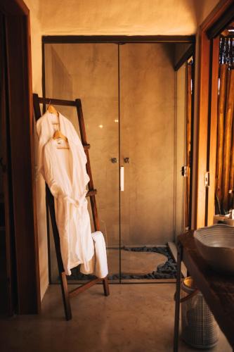 a bathroom with a shower and a chair with a robe at Vila Cerrado in Alto Paraíso de Goiás