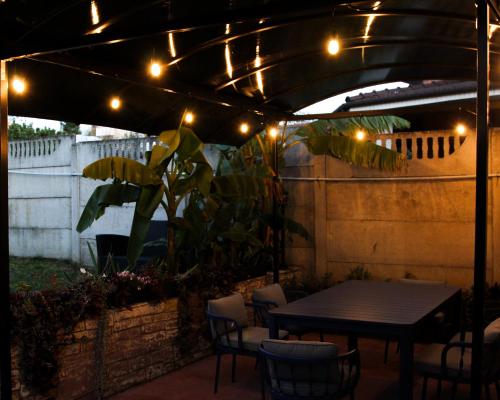 a patio with a table and chairs and lights at Cozy Cottage - Free Parking, Self Check-in in Oradea