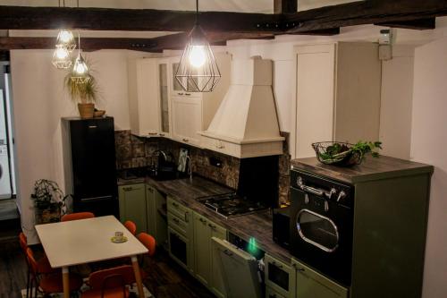 a kitchen with green cabinets and a stove top oven at Cozy Cottage - Free Parking, Self Check-in in Oradea