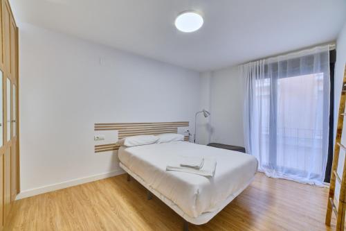 Habitación blanca con cama y ventana en Apartamento el Lobo by Clabao en Logroño