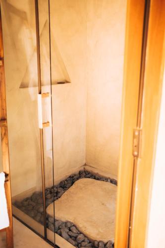 a glass shower door with a bed in a room at Vila Cerrado in Alto Paraíso de Goiás