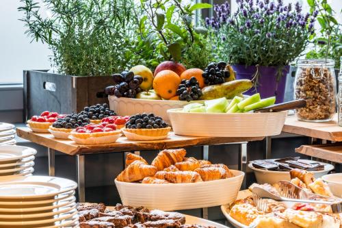 a buffet of food with baskets of fruit and pastries at Craft Beer Central Hotel in Gdańsk