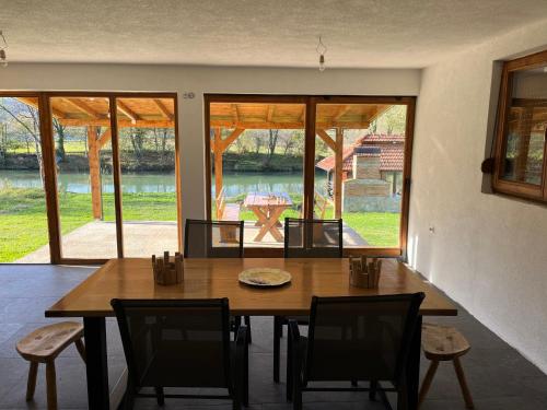 a dining room with a wooden table and chairs at Vikendica Krupa na Vrbasu in Banja Luka