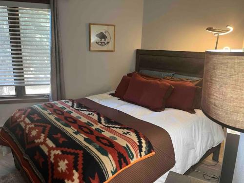 Un dormitorio con una cama con una manta. en New Remodel Shuttle to AF Resort, en Angel Fire