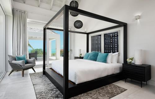 a bedroom with a black and white canopy bed at Ocean Dream 2 BR Villa Blue in Long Bay Hills
