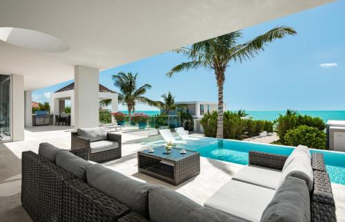 a living room with a couch and chairs and a pool at Ocean Dream 2 BR Villa Blue in Long Bay Hills