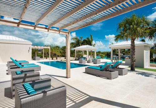 a patio with lounge chairs and a swimming pool at Moringa Villa in Long Bay Hills