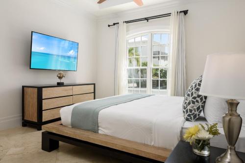 a bedroom with a bed and a tv on a wall at Salt Life Villa in Long Bay Hills