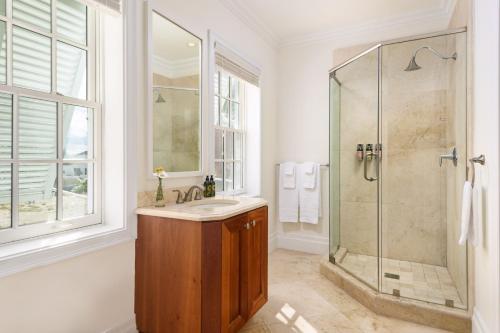 a white bathroom with a shower and a sink at Salt Life Villa in Long Bay Hills