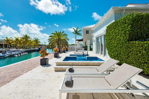 a villa with a swimming pool and a house at Salt Life Villa in Long Bay Hills