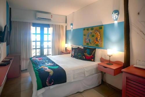 a bedroom with a large bed and a window at Bruno Marambaia Charme Hotel in Beberibe