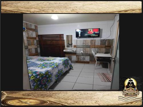 a room with a bed and a sink and a television at Pousada Piratas Di San Rocco in Maceió