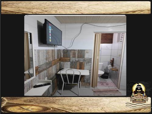 a room with a bathroom with a table and a toilet at Pousada Piratas Di San Rocco in Maceió