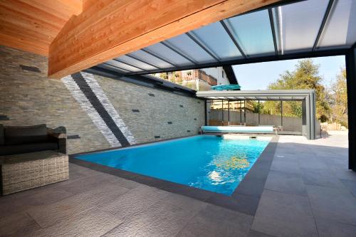 uma piscina interior numa casa com toldo em La Flémingîte em Scionzier