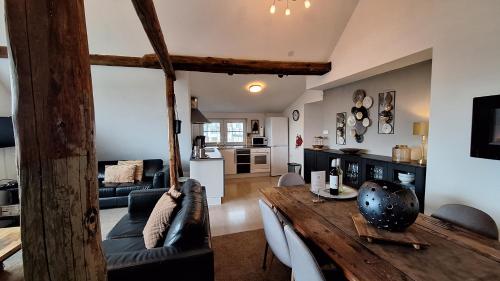 a living room with a wooden table and a kitchen at Group Haus Blick am Edersee 13P in Waldeck