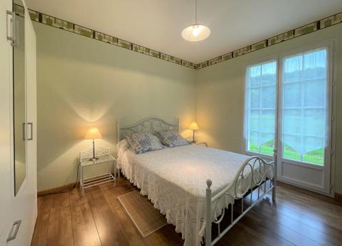 a bedroom with a bed and a large window at Chez estecahandy in Esquiule