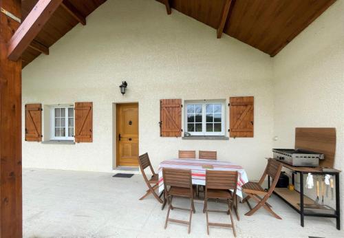 d'une terrasse avec une table, des chaises et une porte. dans l'établissement Chez estecahandy, à Esquiule