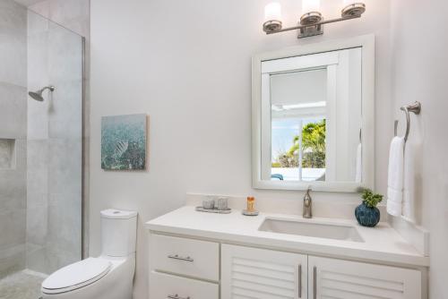 a white bathroom with a sink and a mirror at Second Wind Villa in Long Bay Hills