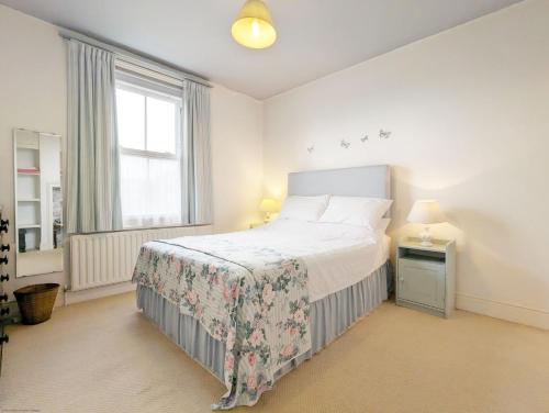 a white bedroom with a bed and a window at Thorney Road in Emsworth