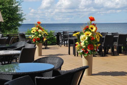 an outdoor patio with tables and chairs and flowers at Villa Anna in Apšuciems