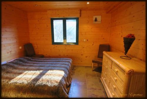 a bedroom with a bed in a log cabin at High standing chalet / SPA overlooking the valley in Eyne